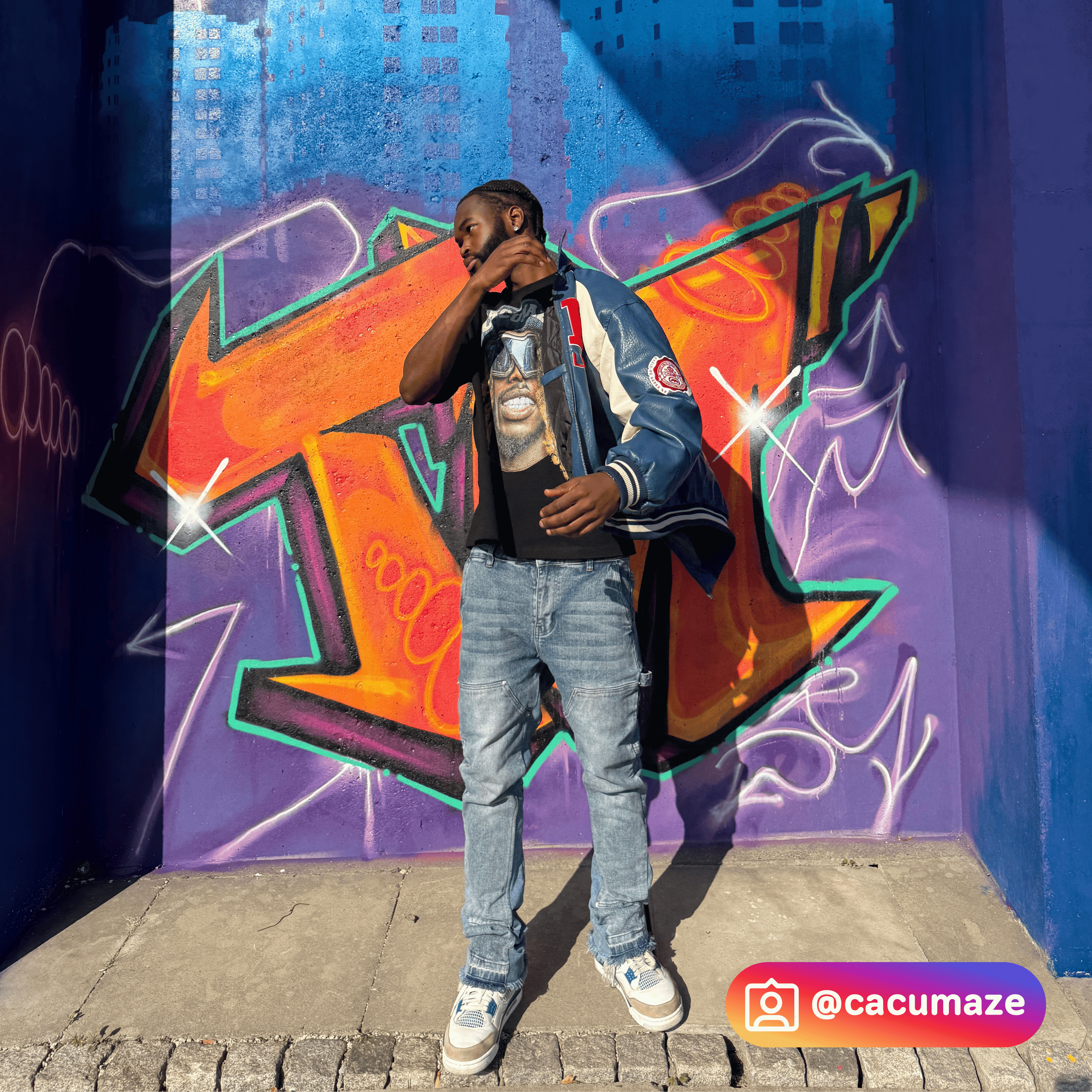 Person standing in front of a colourful graffiti wall with Cacumaze's Instagram handle visible.